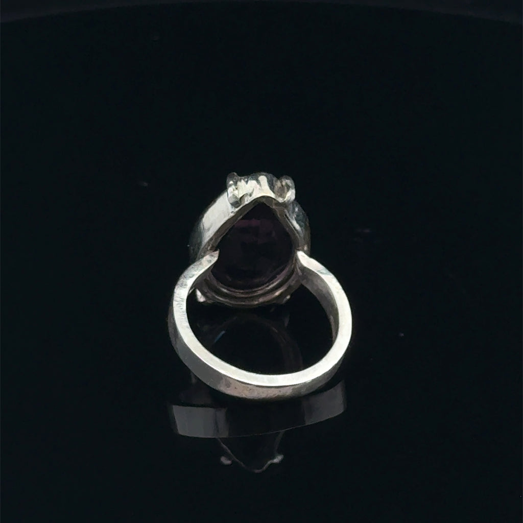 An Ametrine Ring with a purple teardrop-shaped gemstone on a  black  background, back view.