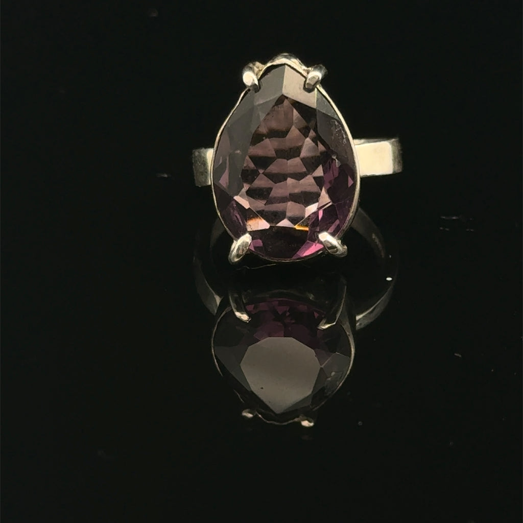 An Ametrine Ring with a purple teardrop-shaped gemstone on a  black  background,  front view.