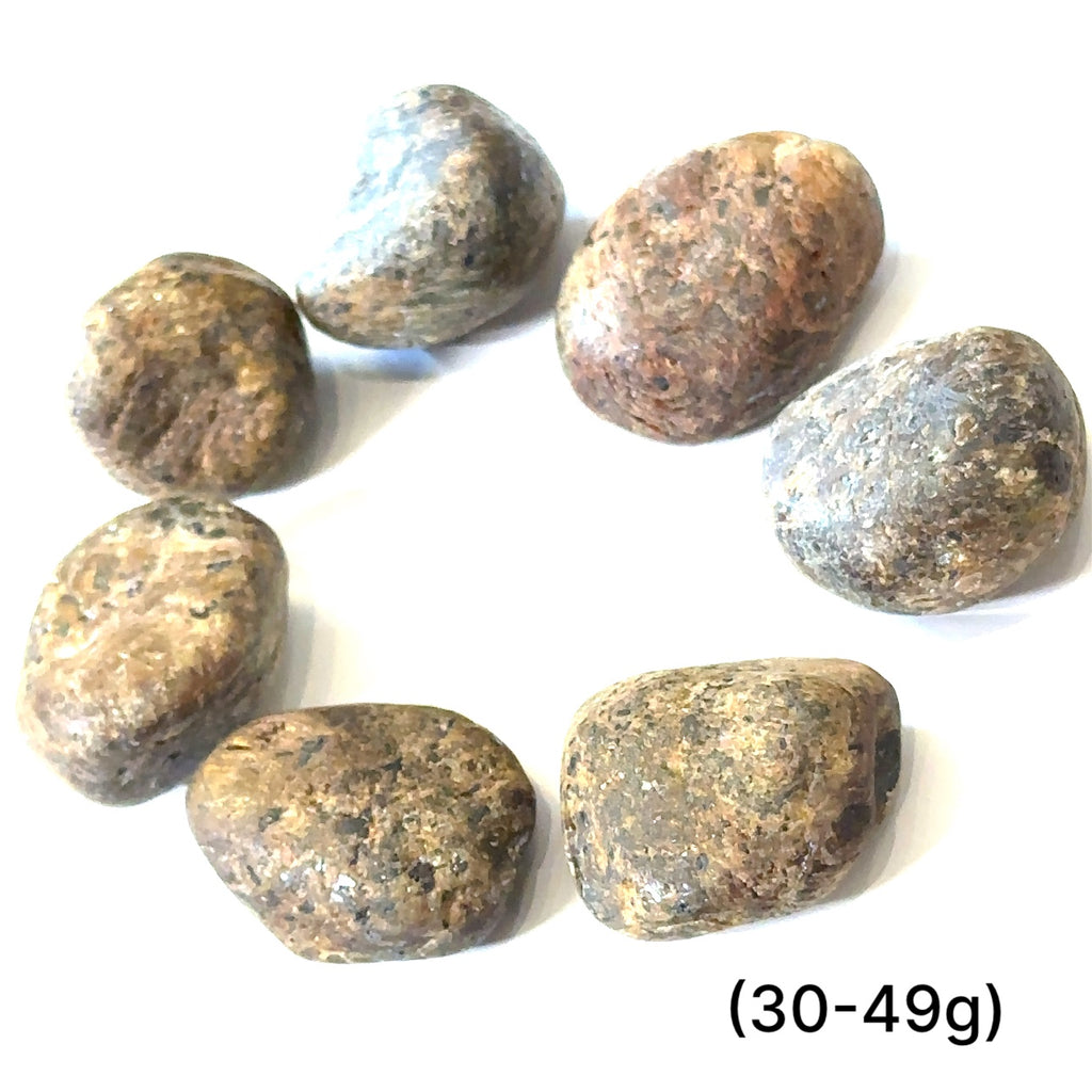 Assorted Golden Sapphire stones showing golden reflections and rich brown tones representing prosperity and determination grouping of (30-49g) on white overview
