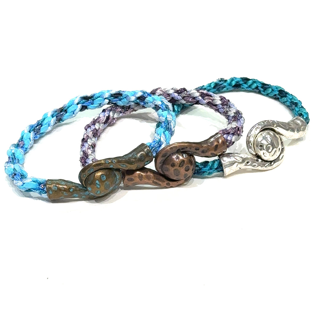 Assorted Kumihimo bracelets in different colors, handcrafted by Hidden Jewel of the South End on white overview