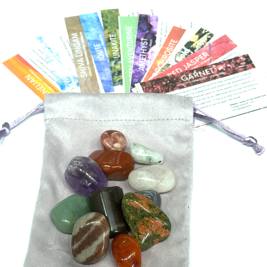 Assorted colorful stones in a drawstring bag with labeled stones on a white background, front view.