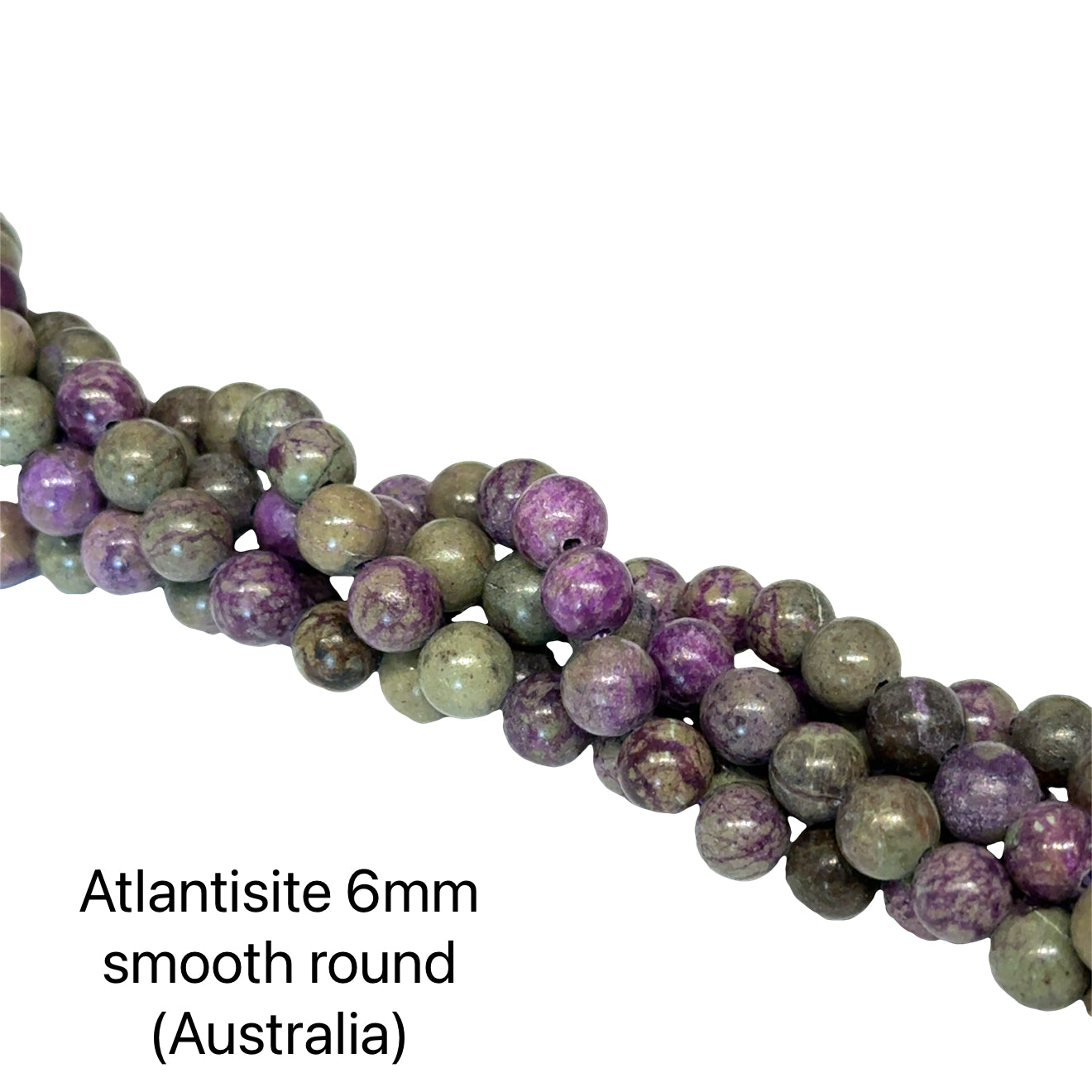 Atlantisite Stichtite 6mm round smooth gemstone strand on a white background, overview. 