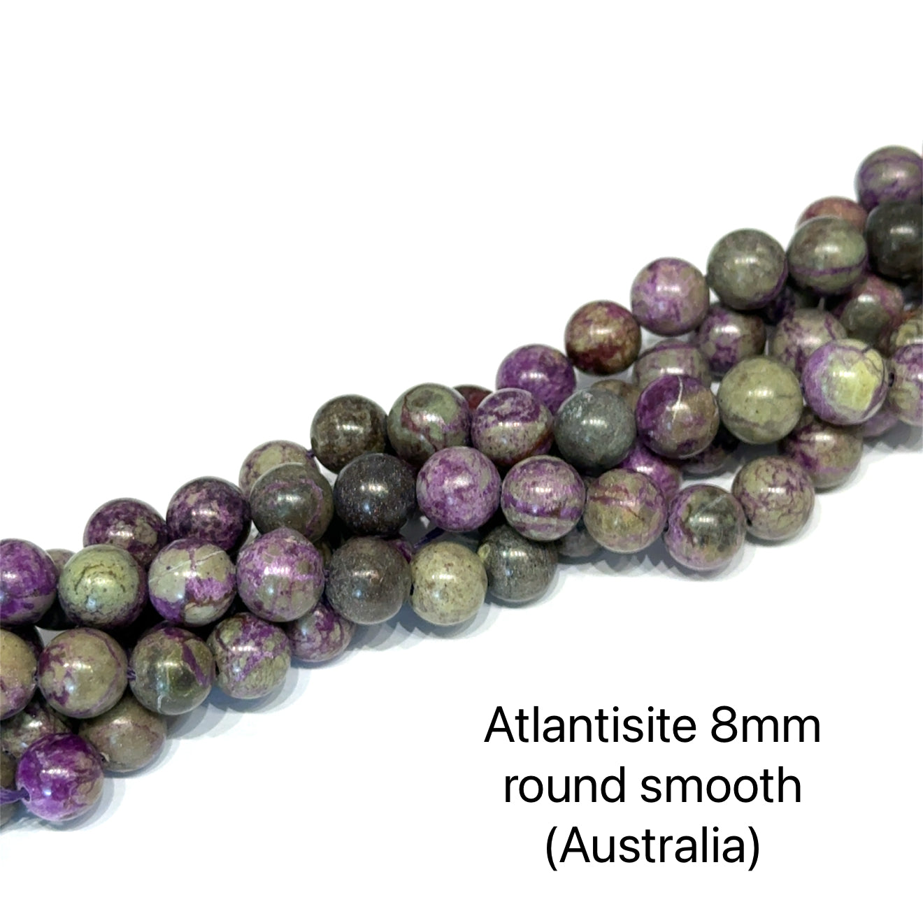 Atlantisite Stichtite 8mm round smooth gemstone strand on a white background, overview. 