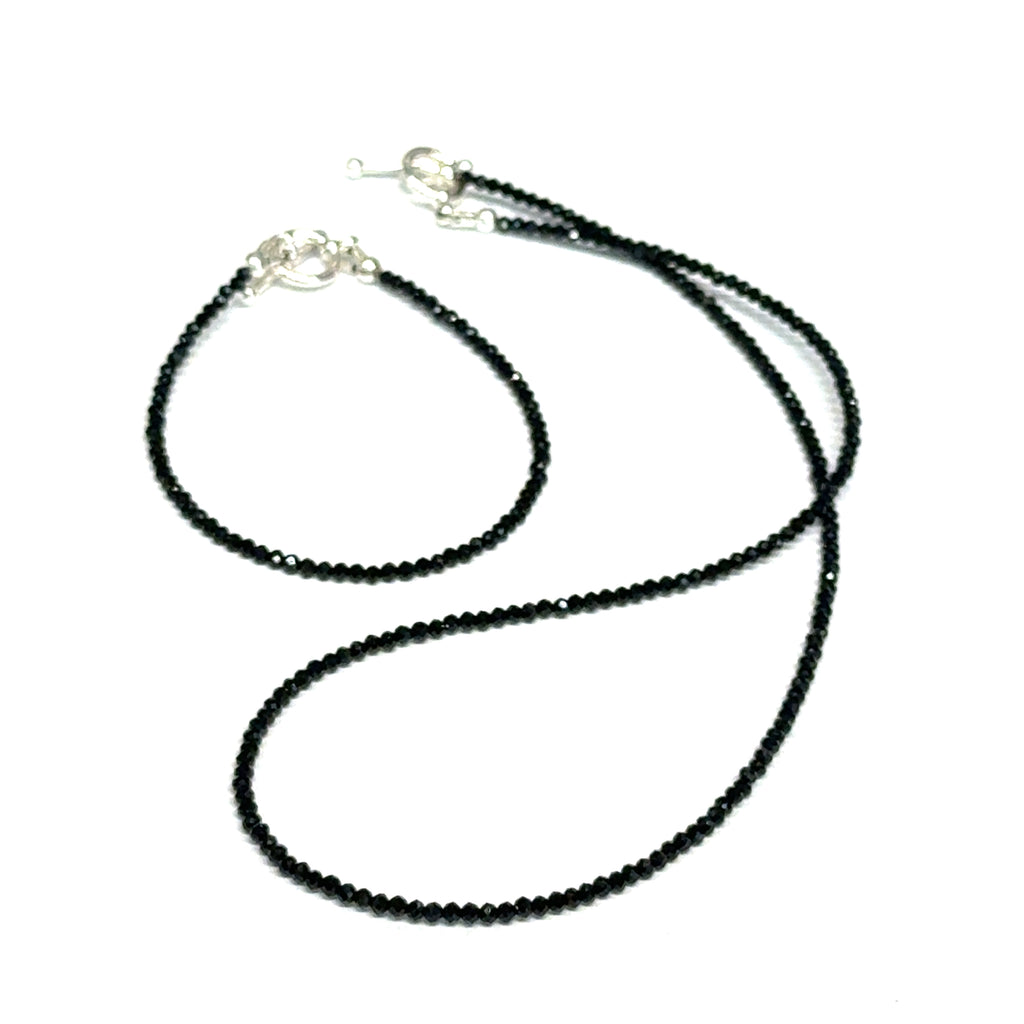 Black Spinel gemstone necklace & it's matching bracelet, both with a sterling silver toggle clasp, genuine gemstone-quality beads, strength and renewal jewelry, on a white background, front overview. 