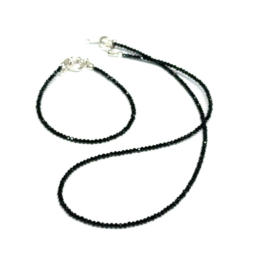 Black Spinel gemstone necklace & it's matching bracelet, both with a sterling silver toggle clasp, genuine gemstone-quality beads, strength and renewal jewelry, on a white background, front overview. 