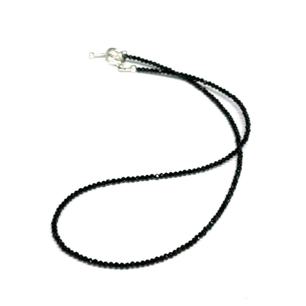 Black Spinel gemstone necklace with a sterling silver toggle clasp, genuine gemstone-quality beads, strength and renewal jewelry, on a white background, front overview. 