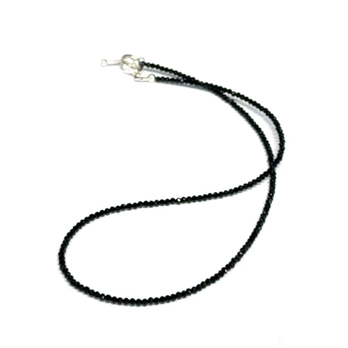 Black Spinel gemstone necklace with a sterling silver toggle clasp, genuine gemstone-quality beads, strength and renewal jewelry, on a white background, front overview. 