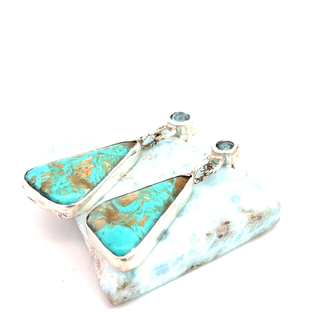 Blue Zircon and Royston Turquoise sterling silver drop earrings — handcrafted by Hidden Jewel South End on a white background lifted by a gemstone front  left side close up view
