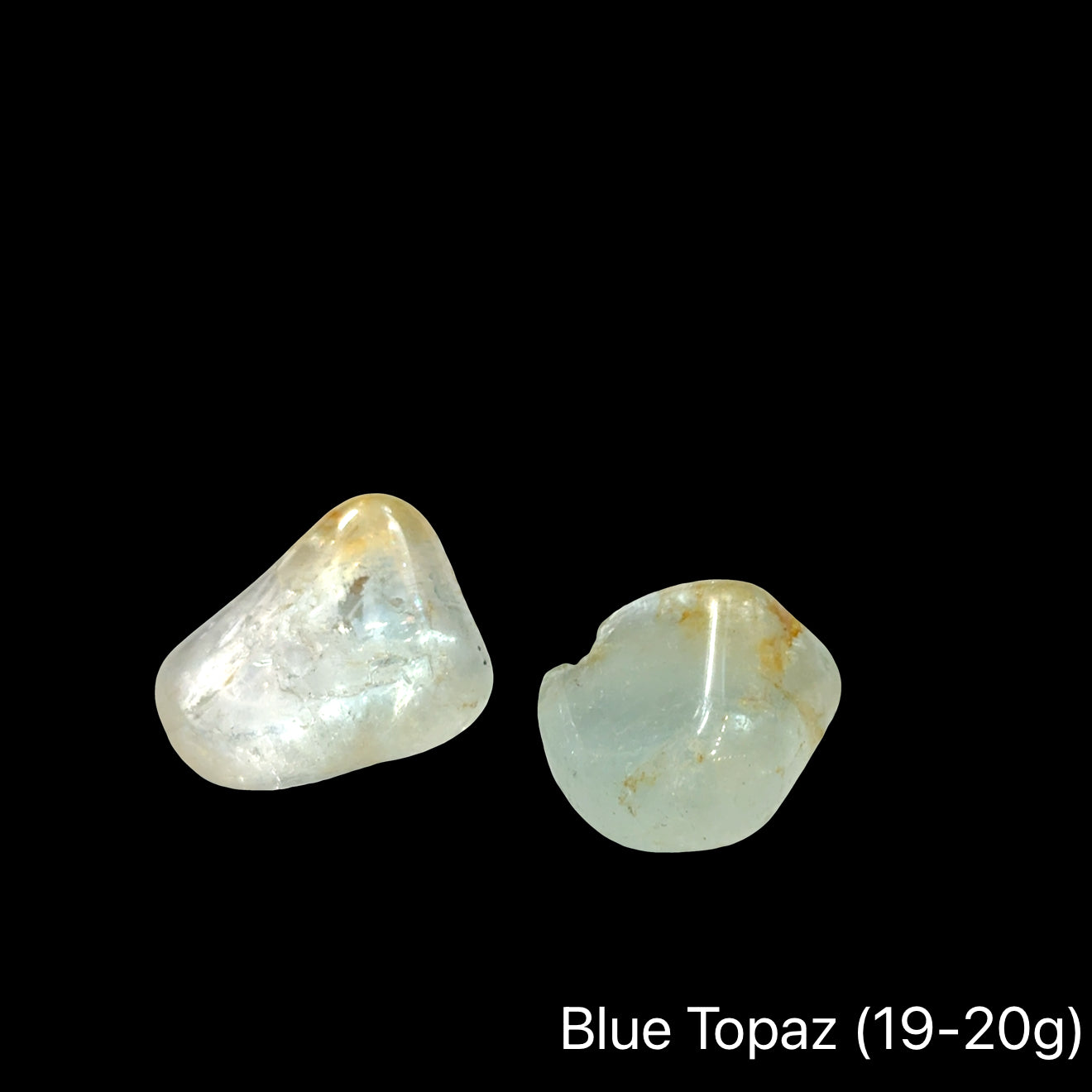 Blue topaz stones, 19-20g each, on a black background, front view.