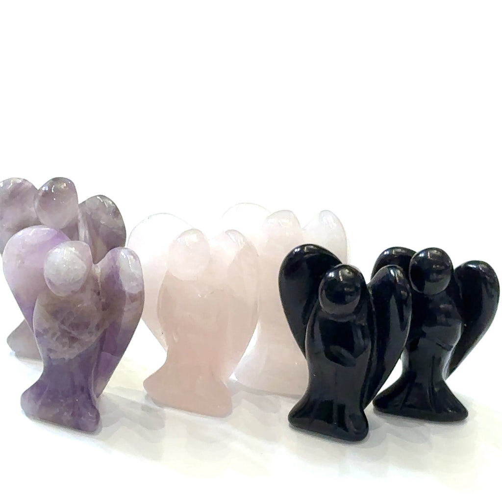 Carved gemstone angel figurine made from Rose Quartz for compassion and harmony in a row on white front view