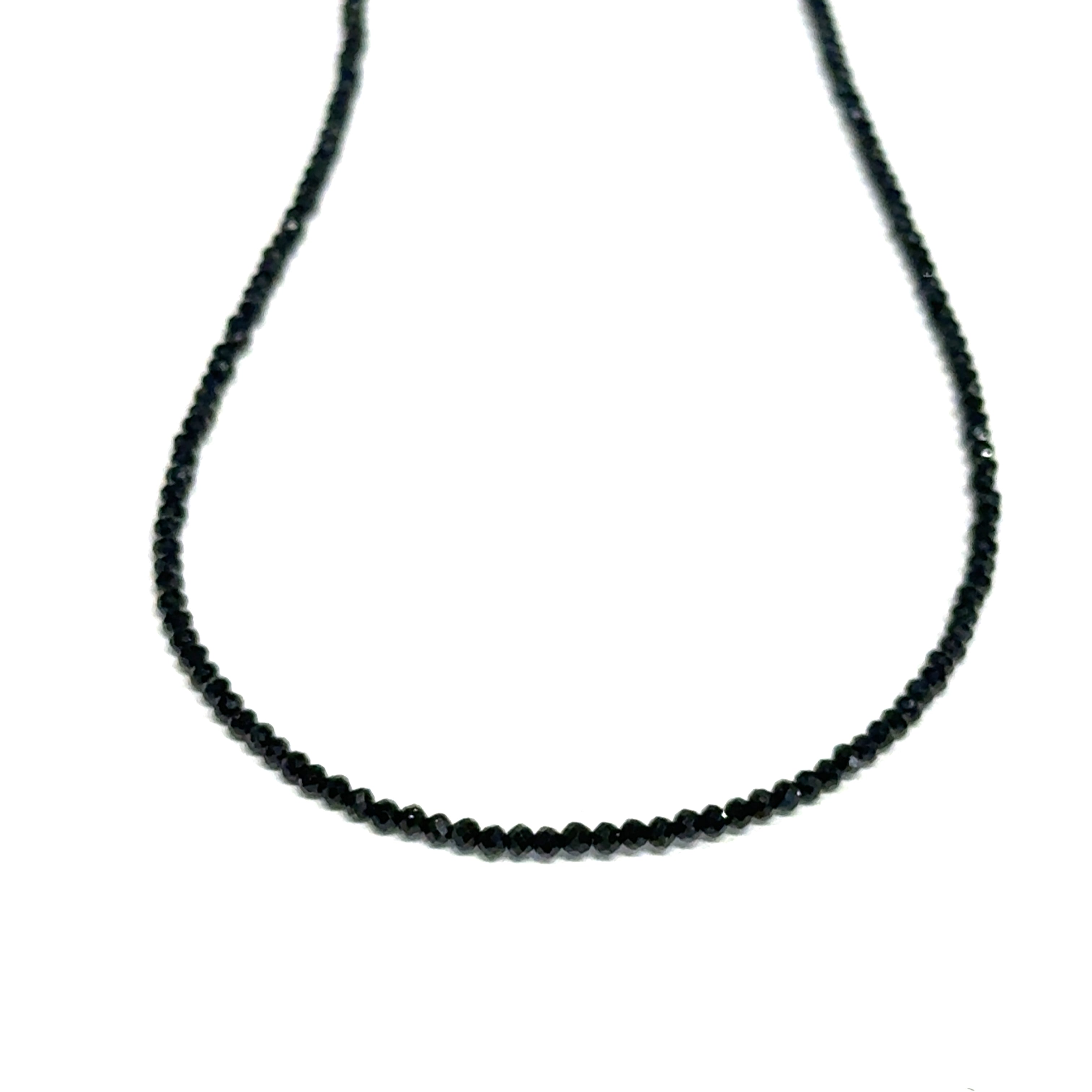 Close-up of Black Spinel beads showing deep black color and brilliant luster, gemstone-quality necklace for power and protection, on a white background, front close up hanging view. 