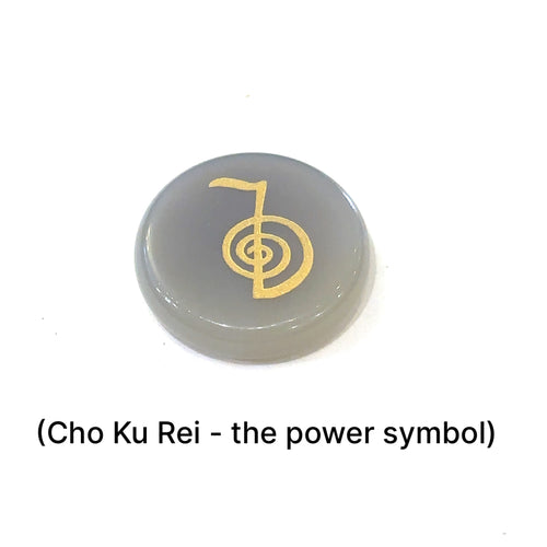 Close-up of Botswana Agate stone showing engraved Cho Ku Rei Power Symbol in gold on a white background front view. 