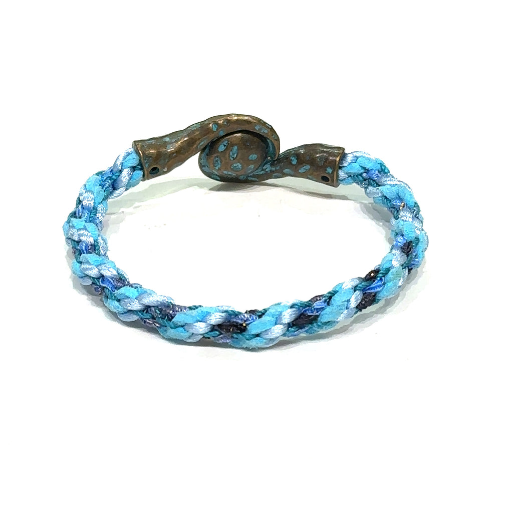 Close-up of Kumihimo braid showing woven texture and color detail. Blue bracelet on white back view