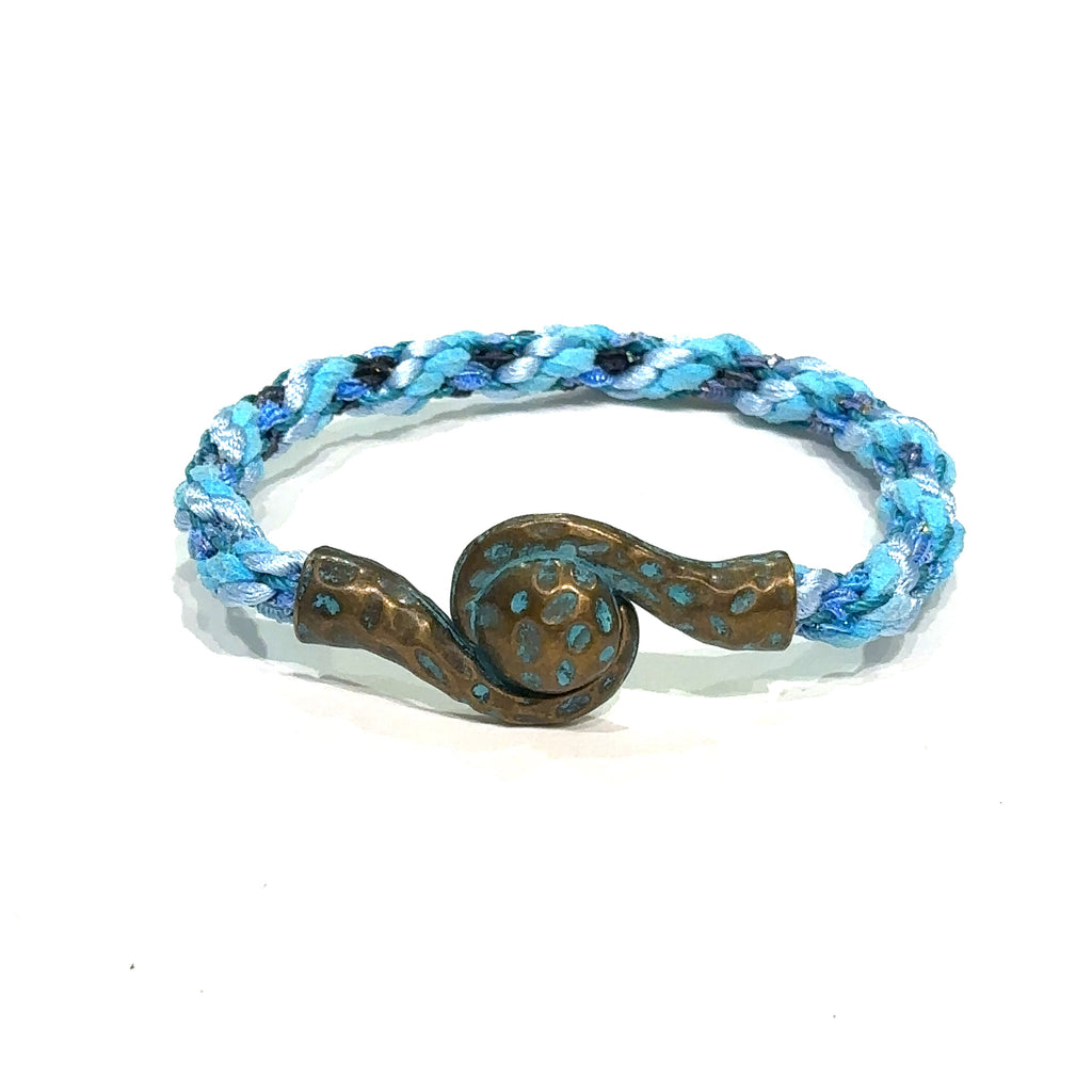 Close-up of Kumihimo braid showing woven texture and color detail. Blue bracelet on white front view