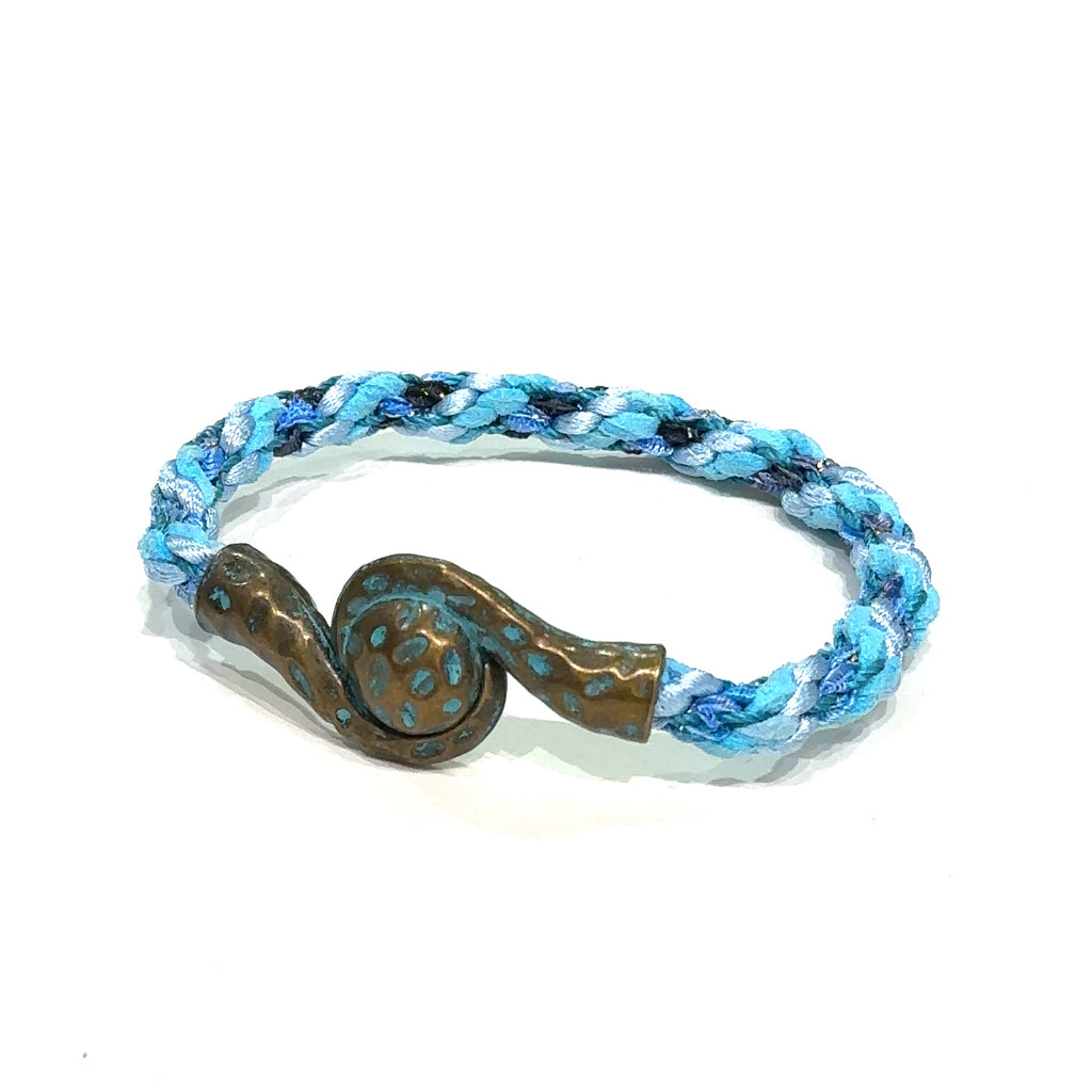 Close-up of Kumihimo braid showing woven texture and color detail. Blue bracelet on white slight left angle view