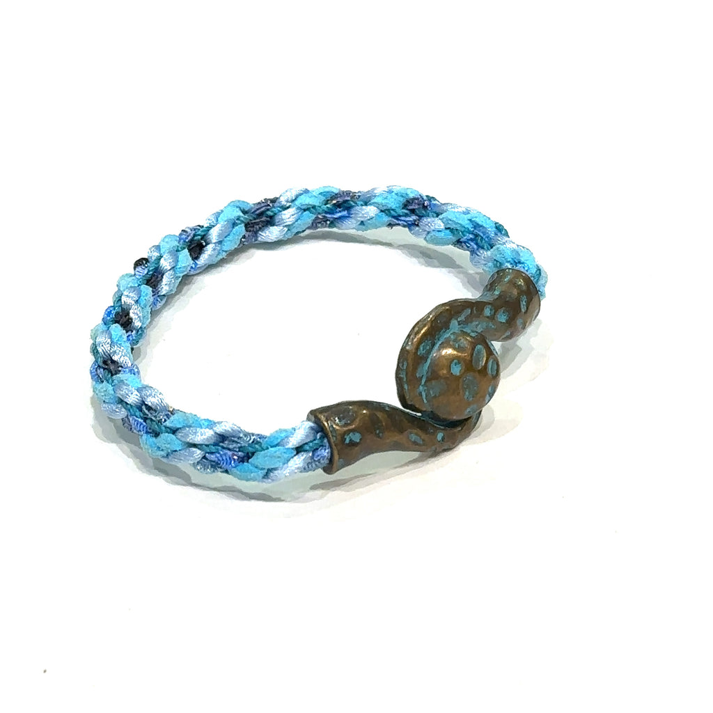 Close-up of Kumihimo braid showing woven texture and color detail. Blue bracelet on white slight right angle view