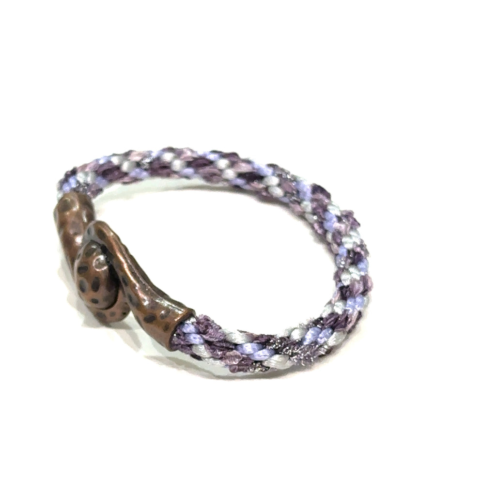 Close-up of Kumihimo braid showing woven texture and color detail purple bracelet  on white left side angle view