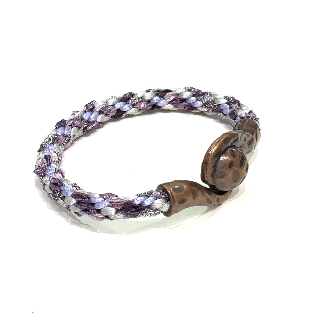 Close-up of Kumihimo braid showing woven texture and color detail purple bracelet  on white right angle view