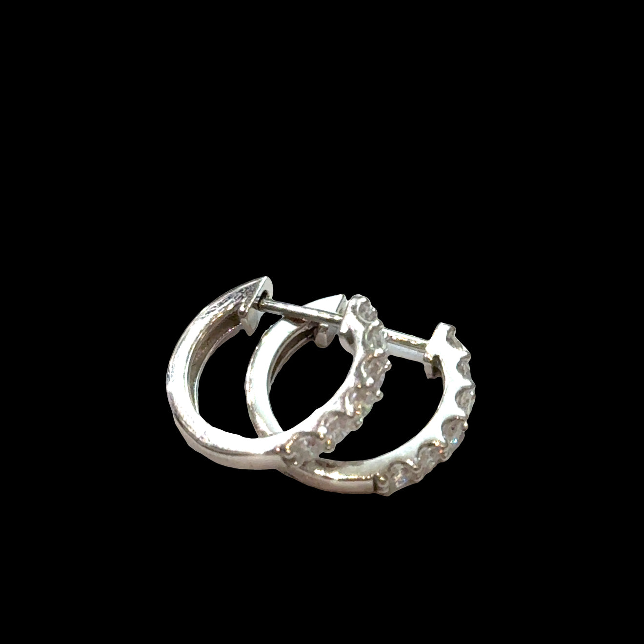 Close-up of diamond huggie hoops 925 silver with secure hinged closure, lab-grown diamonds, hypoallergenic everyday earrings, on a black background, front left-side view.