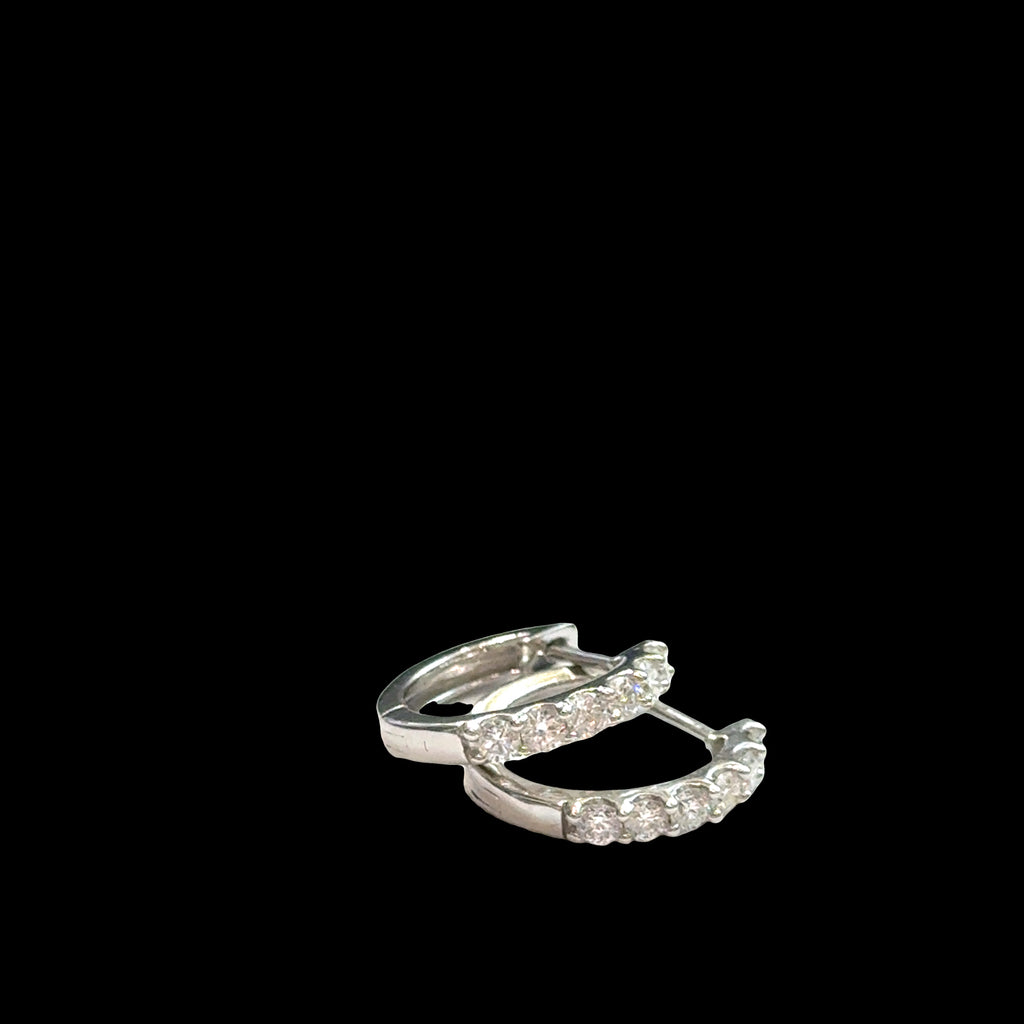 Close-up of diamond huggie hoops 925 silver with secure hinged closure, lab-grown diamonds, hypoallergenic everyday earrings, on a black background, front overview.