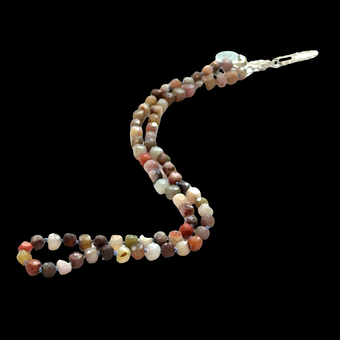 Close-up of genuine Petrified Wood beads showing natural grain patterns, fossilized wood necklace, earthy brown tones, on a black background, front overview.