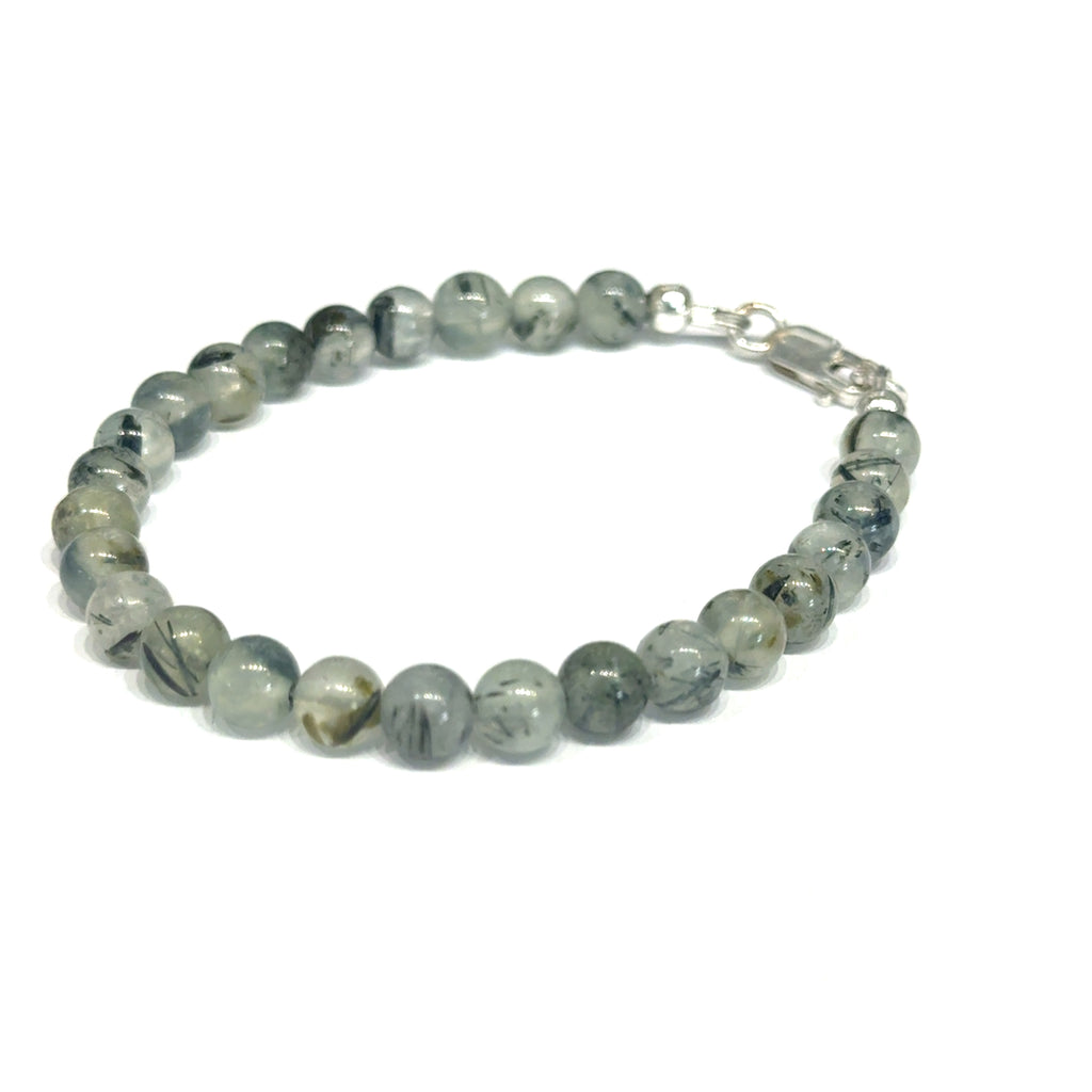 Close-up of natural prehnite beads displaying a soft green color and a smooth, polished finish, size 6.5, on a white background, left angle overview. 