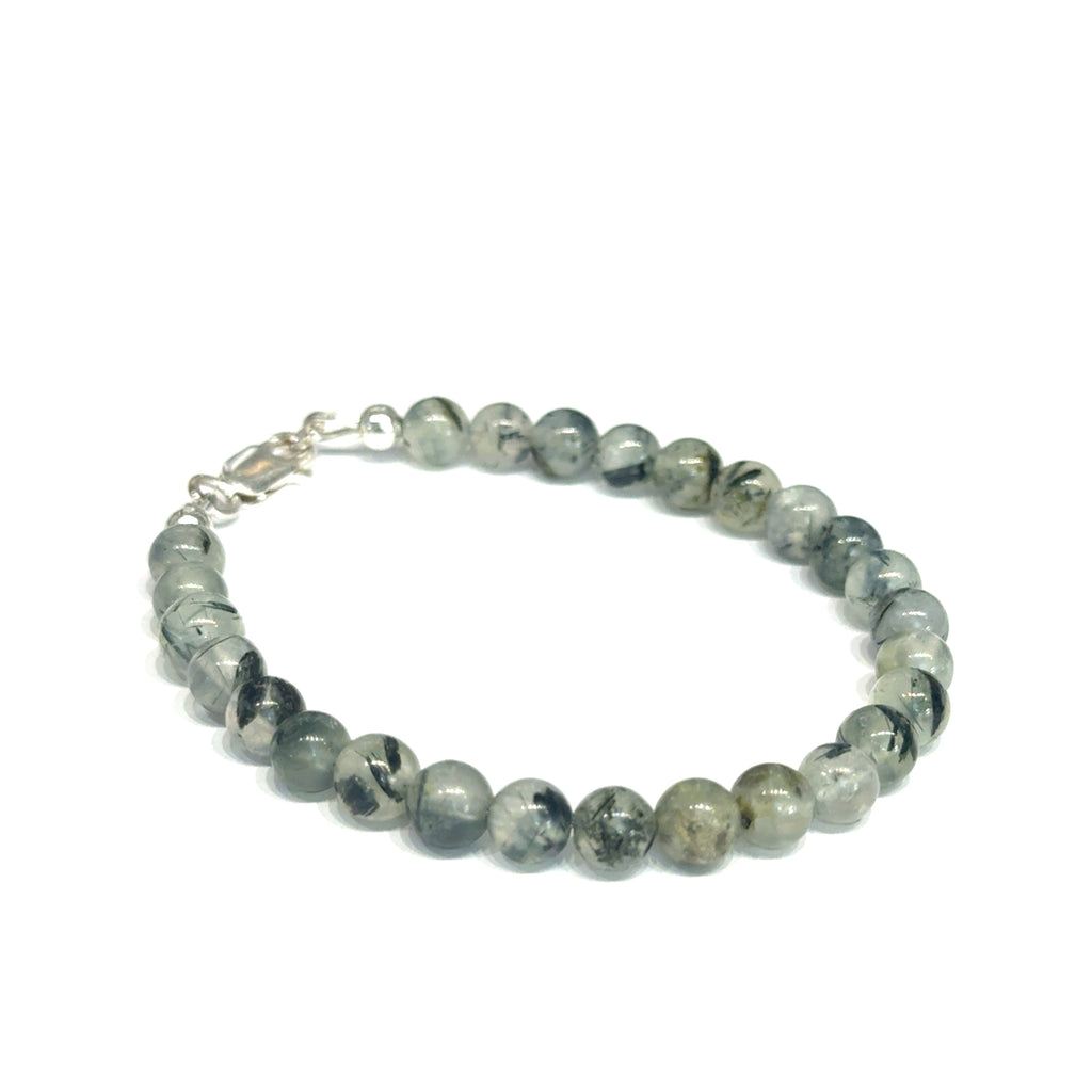 Close-up of natural prehnite beads displaying a soft green color and a smooth, polished finish, size 6.5, on a white background, right angle overview. 