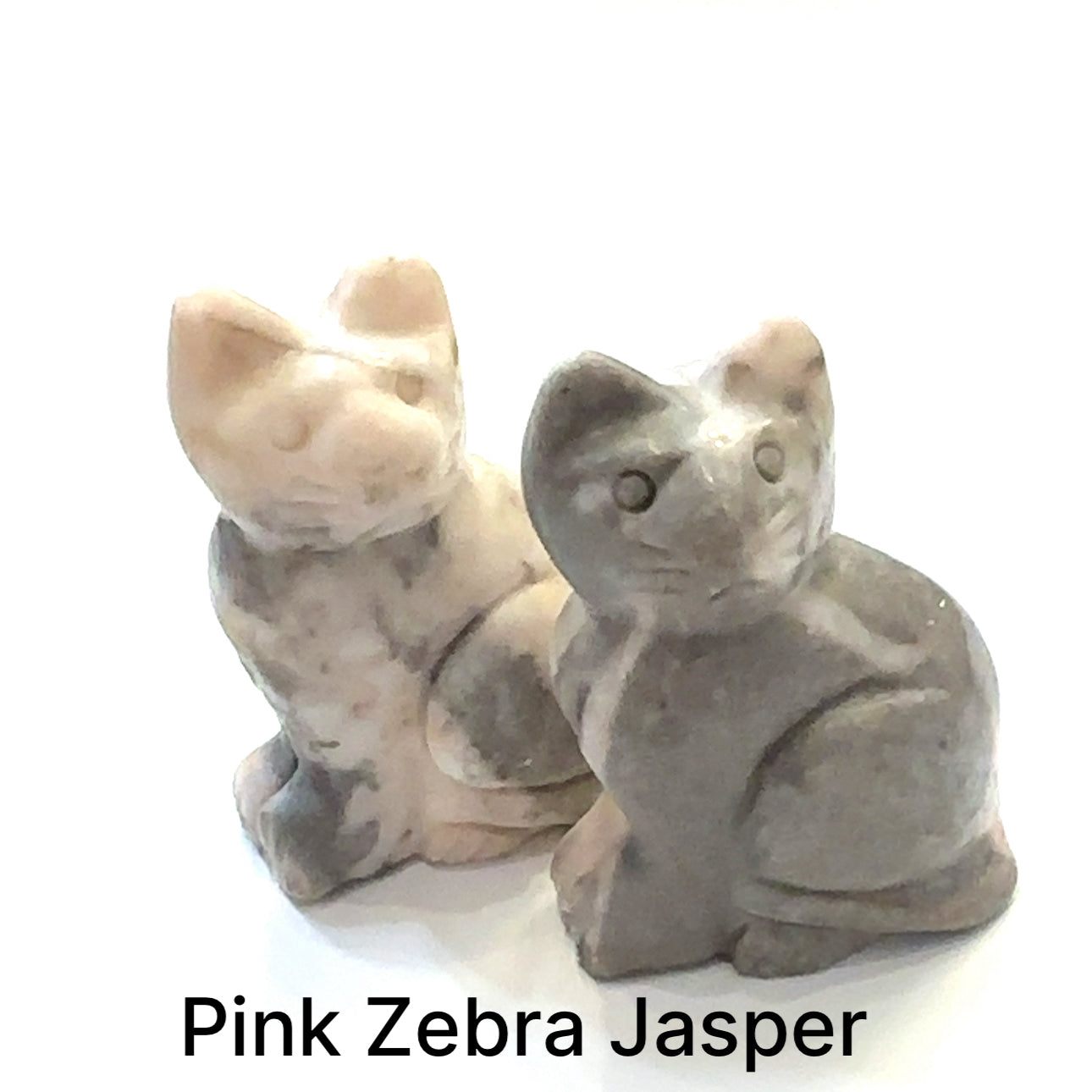 Close-up of polished gemstone cat grouping of Pink Zebra Jasper showing crystal texture and color variation. On white background front overview