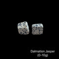Dalmation Jasper stones with a weight range (0-10g) on a black background, front view.