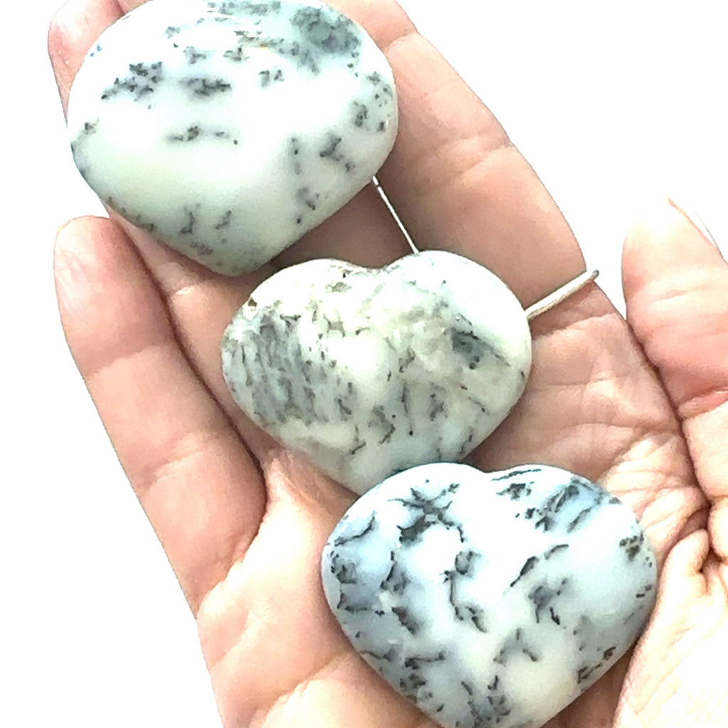 Dendritic Opal Gemstone Heart grouping  in hand on white front view