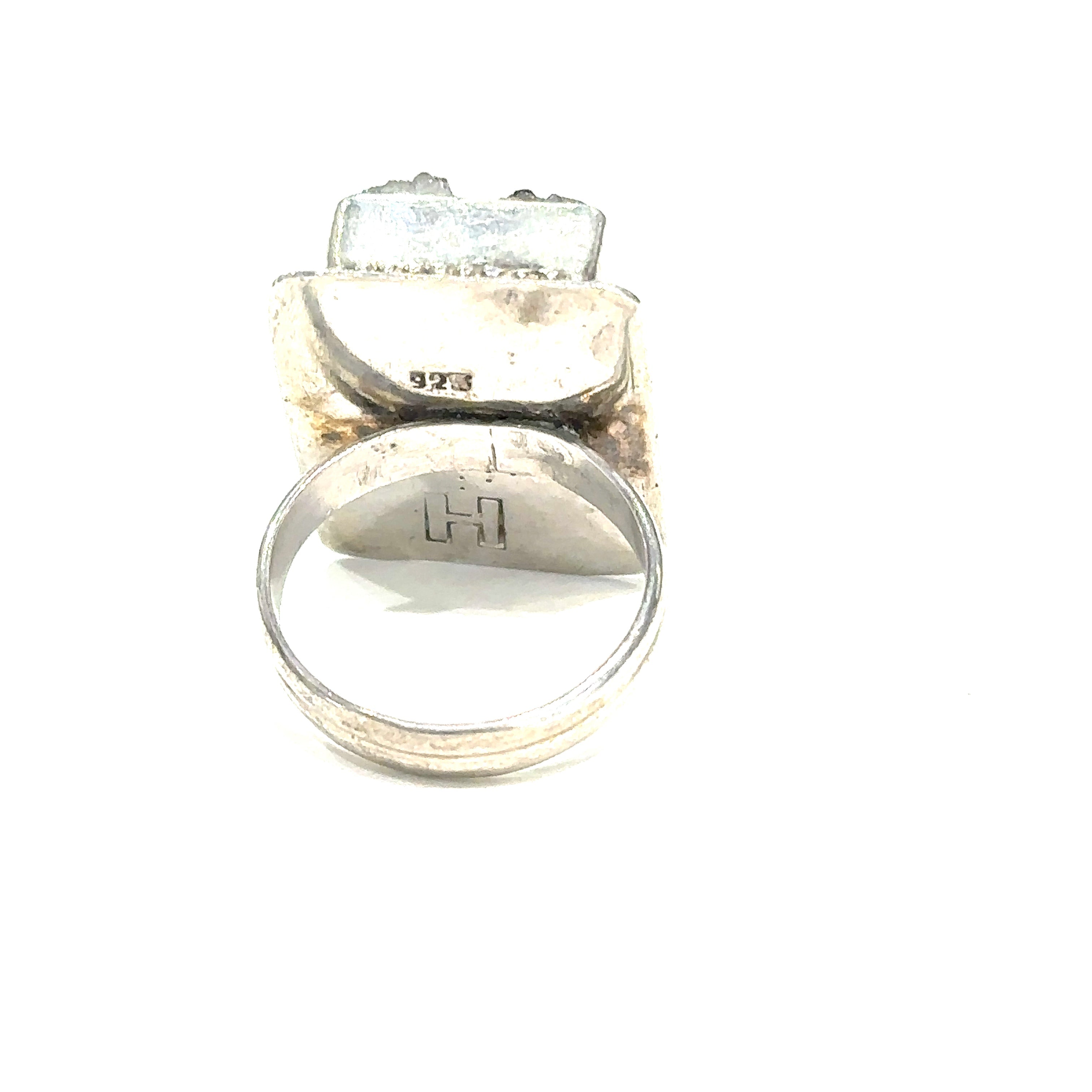 Detailed close-up of natural Amethyst druzy crystal showing purple sparkle and raw texture on white back of ring view