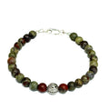 Dragon Blood Jasper gemstone beaded bracelet with sterling silver pattern bead and a lobster claw clasp showing red and green natural patterns  on a white background, front view. 