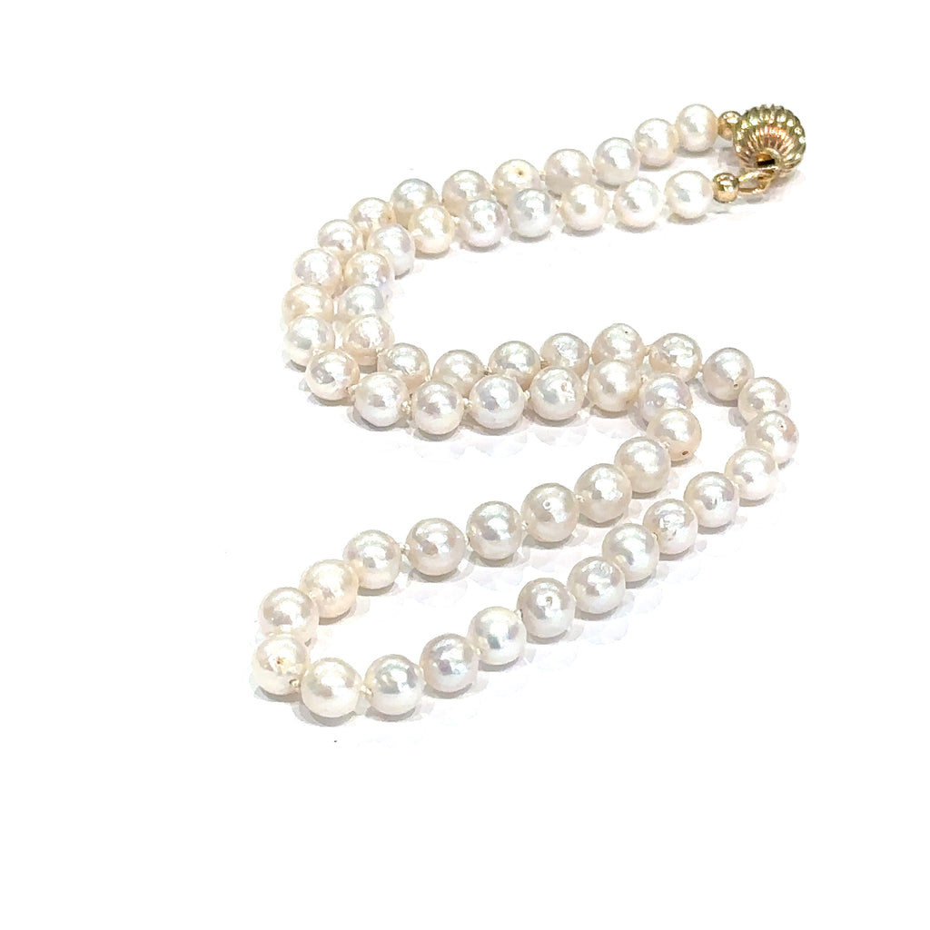 Elegant 18 inch freshwater pearl necklace with irregularly round pearls on white center up close overview
