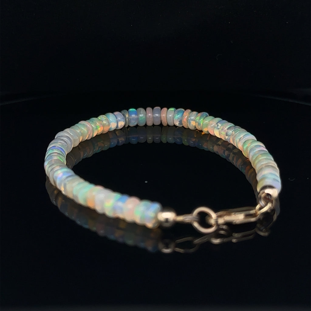 Elegant Ethiopian Opal crystal bracelet available in 6.5'' and 7'' sizes on black back angle view