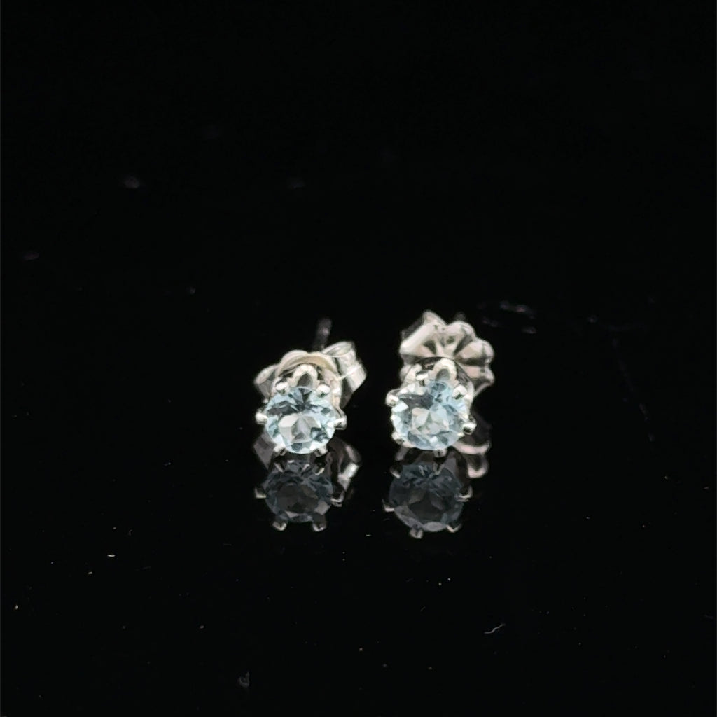 Elegant handmade Blue Topaz earrings for November birthstone gift on black background front overview.