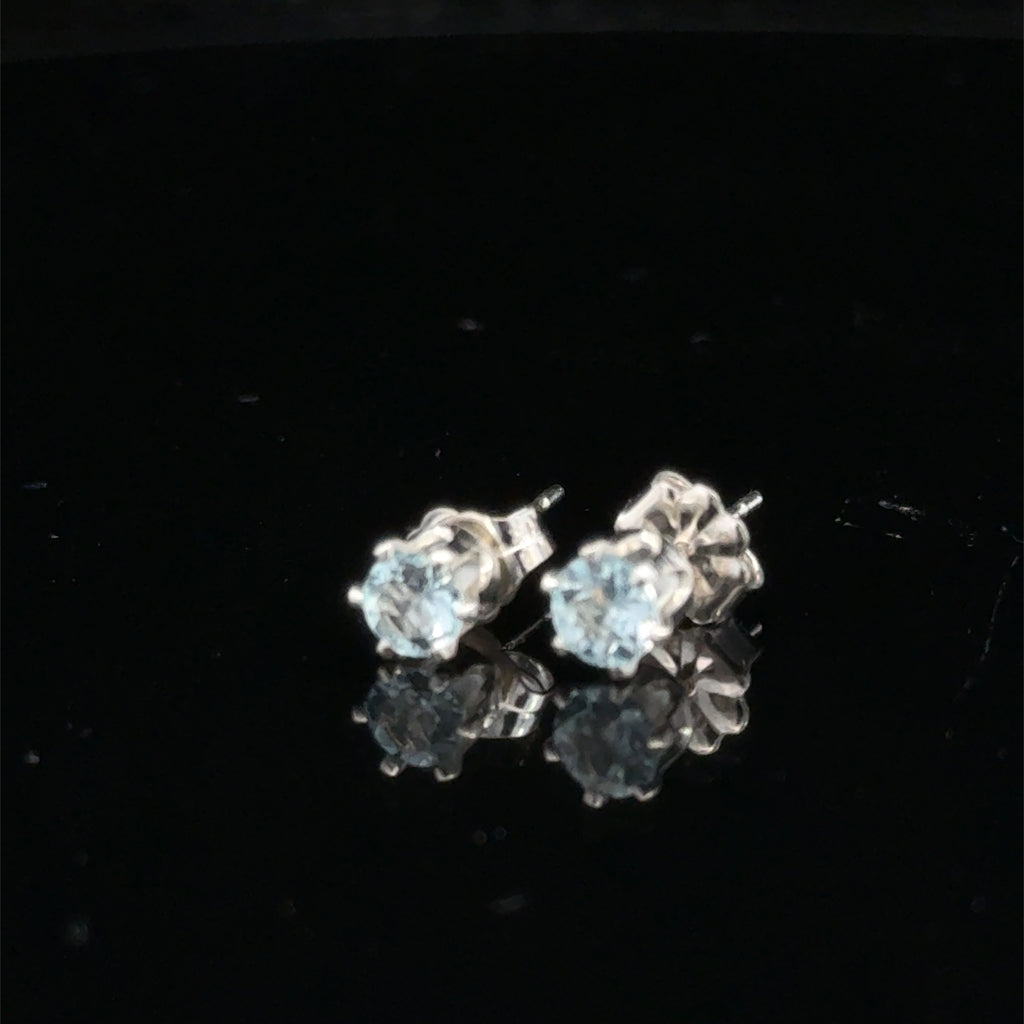 Elegant handmade Blue Topaz earrings for November birthstone gift on black background front slight left overview.