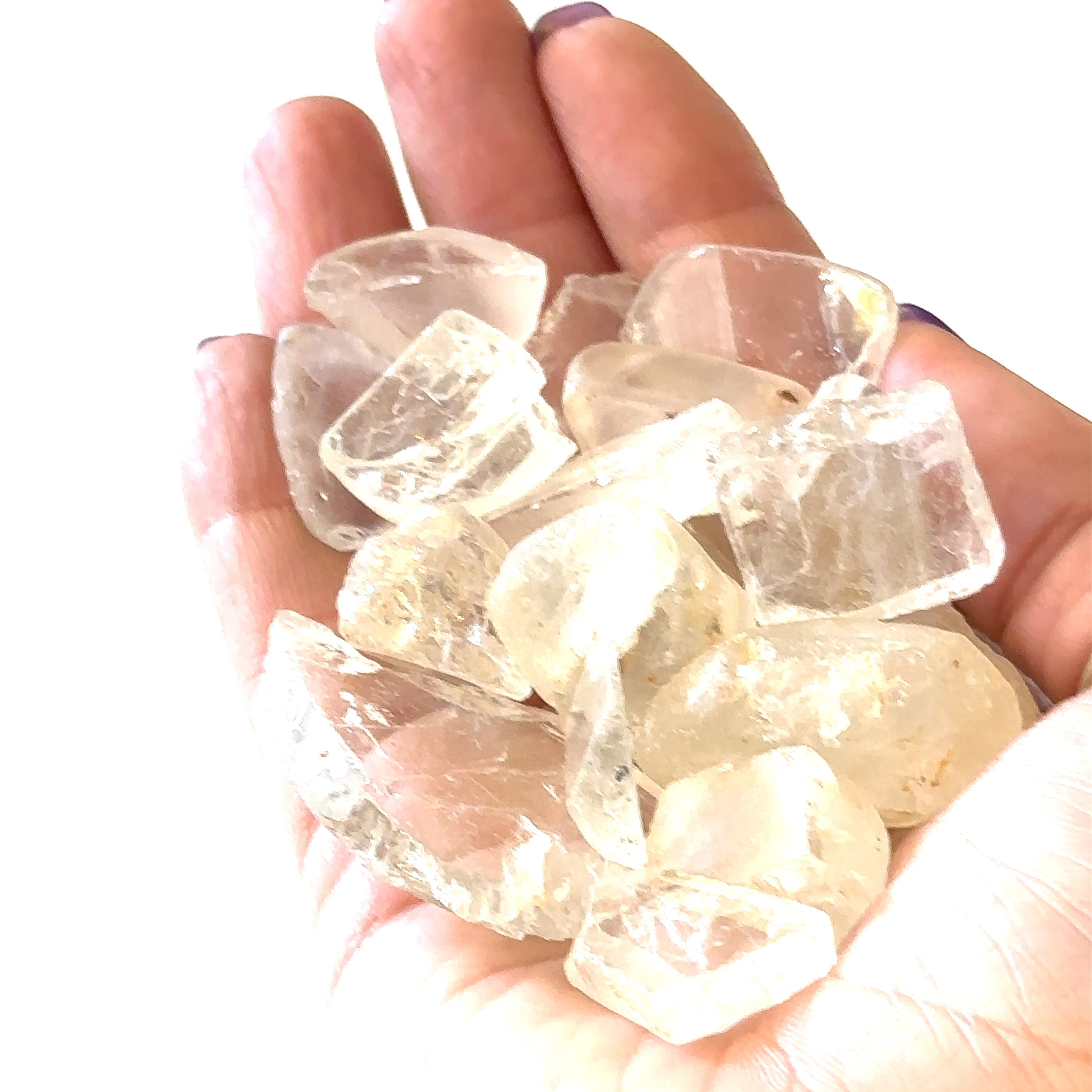 Ethically sourced raw White Topaz gemstone with natural brilliance grouping of gemstones in hand to show close up overview