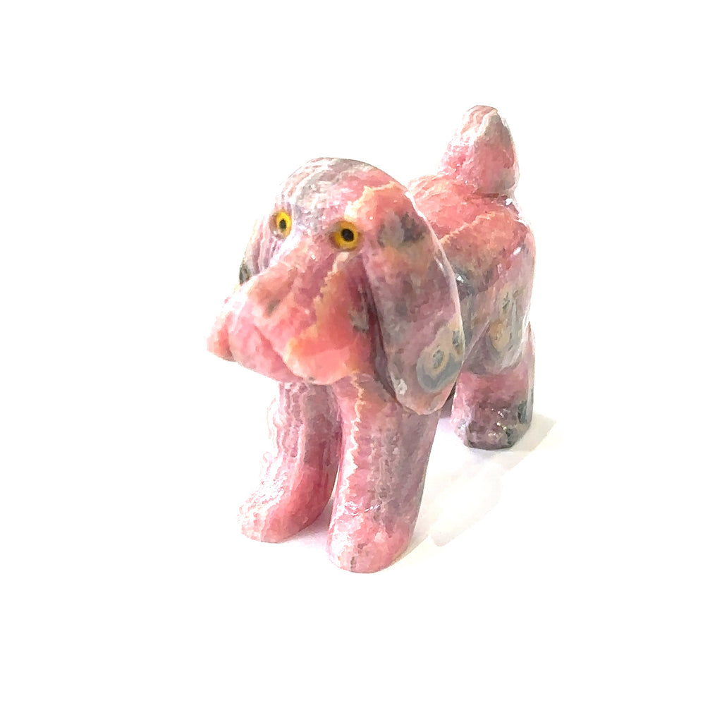 Ethically sourced rhodochrosite gemstone dog carving with natural pink hues on white front angled overview
