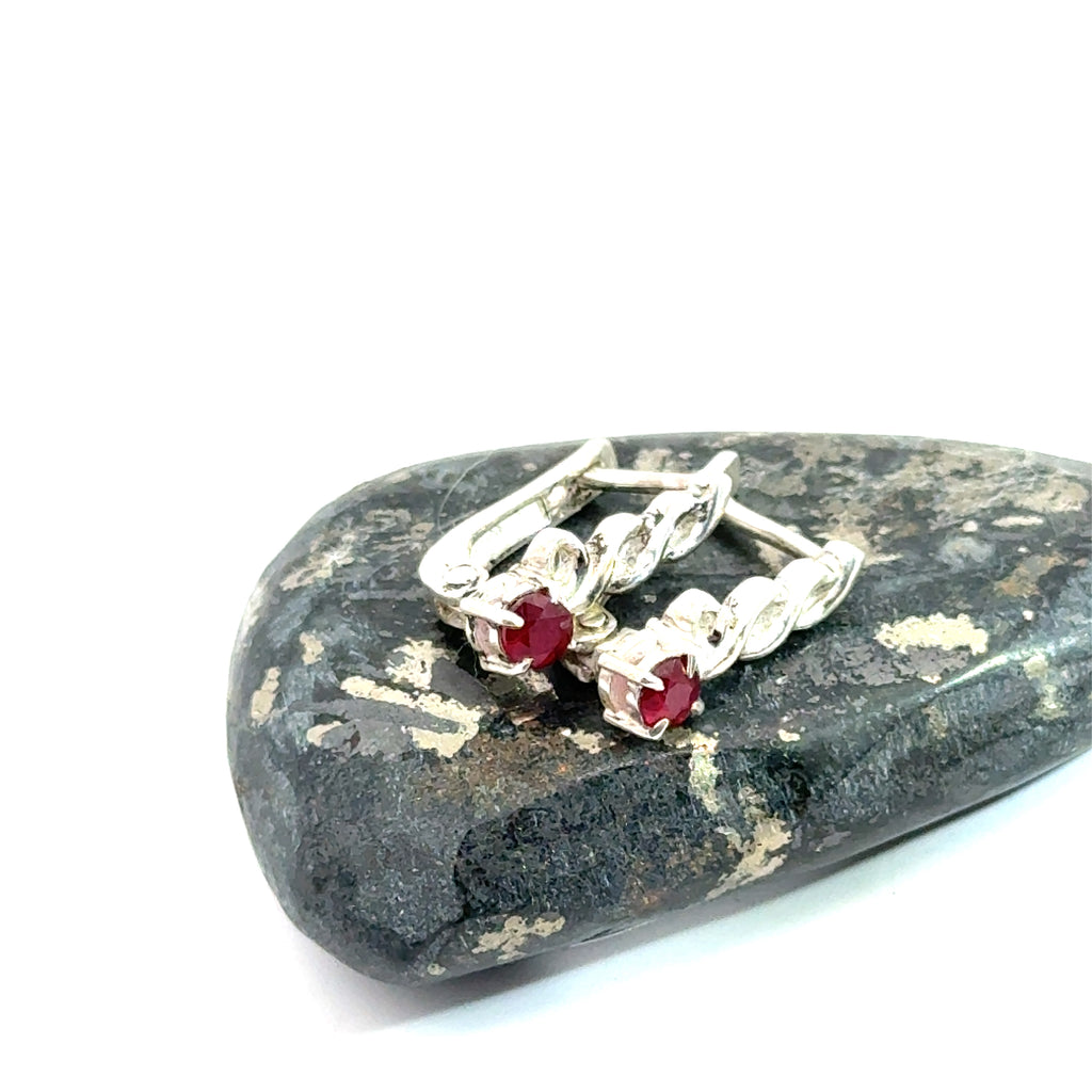Faceted Ruby Snap‑Back Earrings on white and on rock  long front view