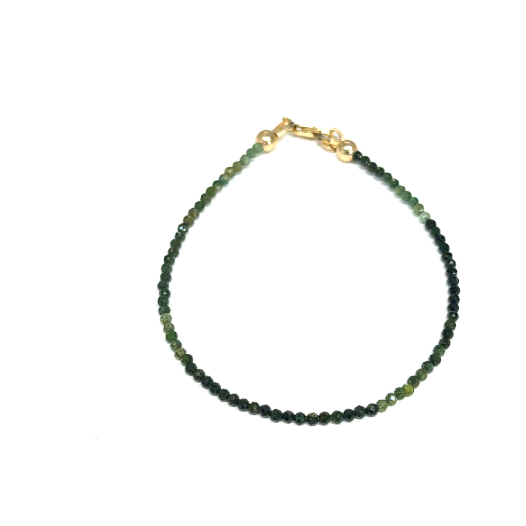 Faceted green tourmaline gemstone bracelet with gold-filled lobster claw clasp on white background, overview.