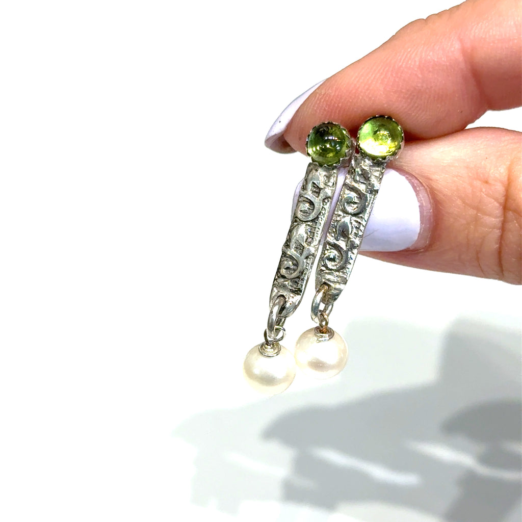 Freshwater Pearl & Peridot Gemstone Earrings in finger tips on white  center overview