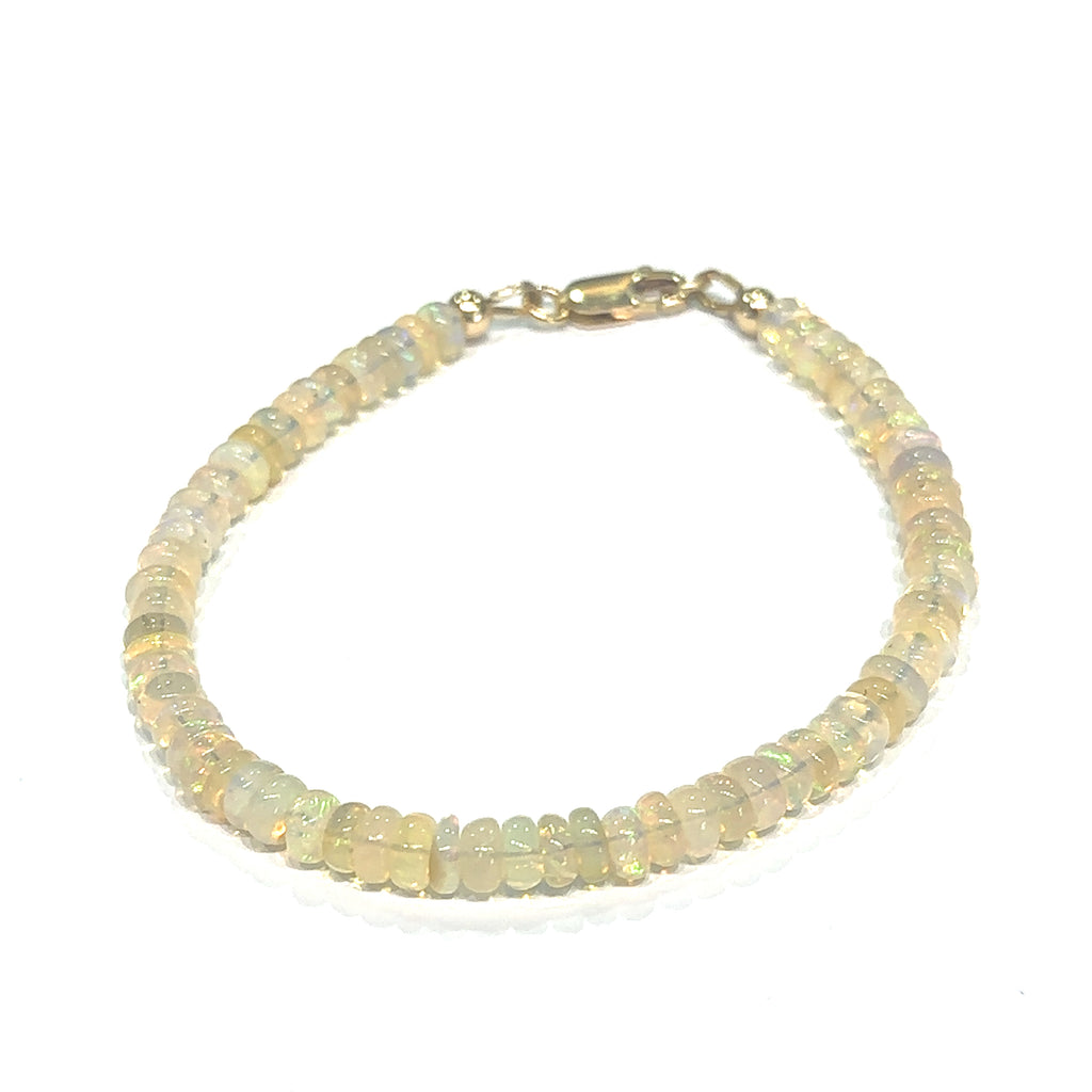 Genuine Ethiopian Opal gemstone bracelet with smooth roundel beads and gold‑filled lobster clasp on white center overview