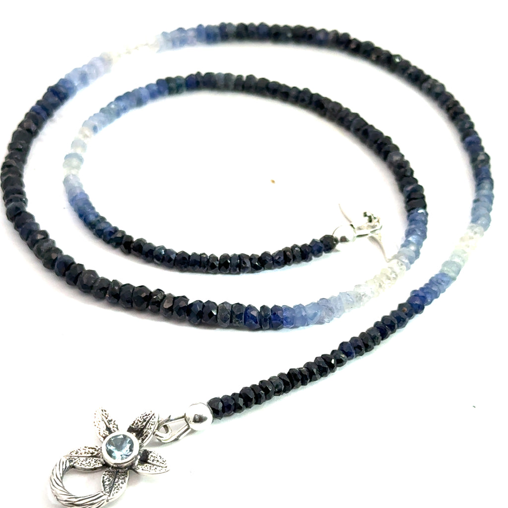Genuine Sapphire gemstone necklace with a sterling silver toggle clasp by Hidden Jewel on a white background, center spiral overview.