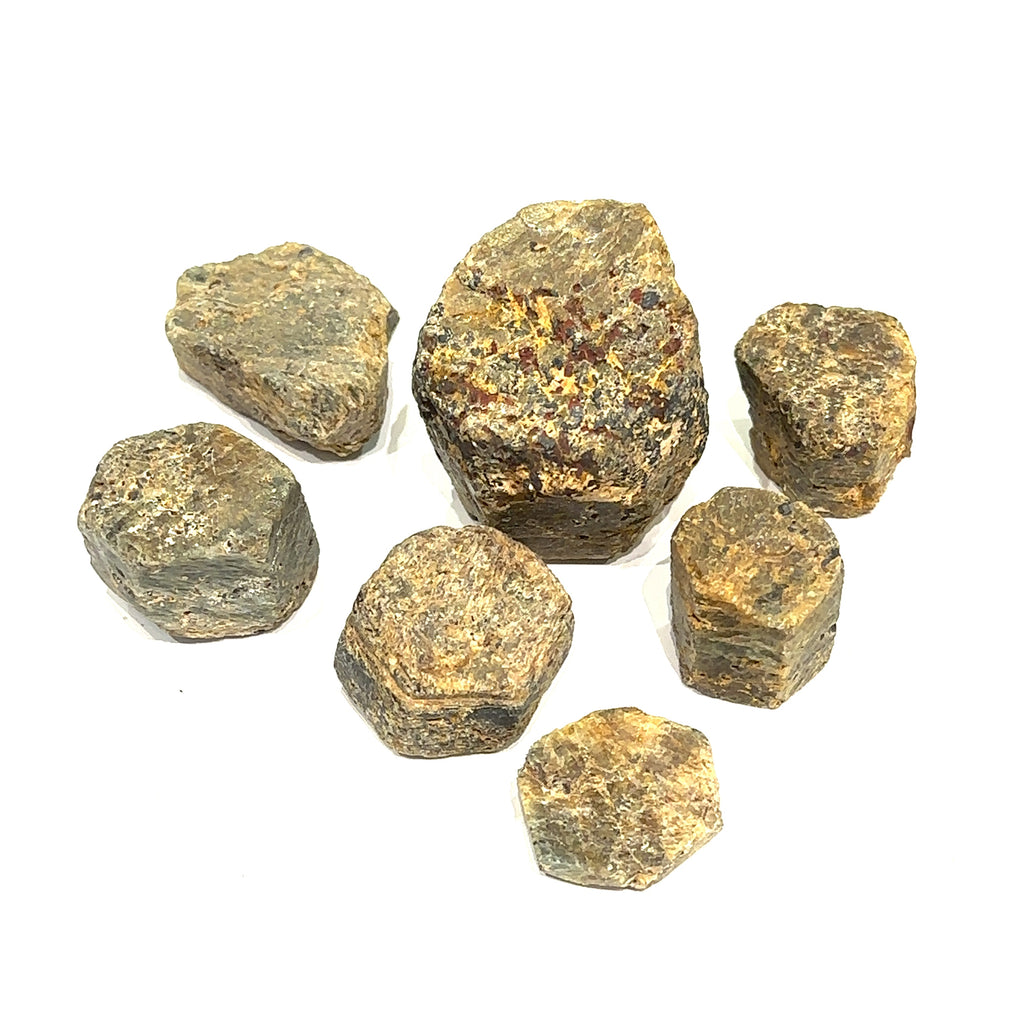 Golden Sapphire raw gemstone with bronze-golden sheen symbolizing strength and prosperity grouping on white overview