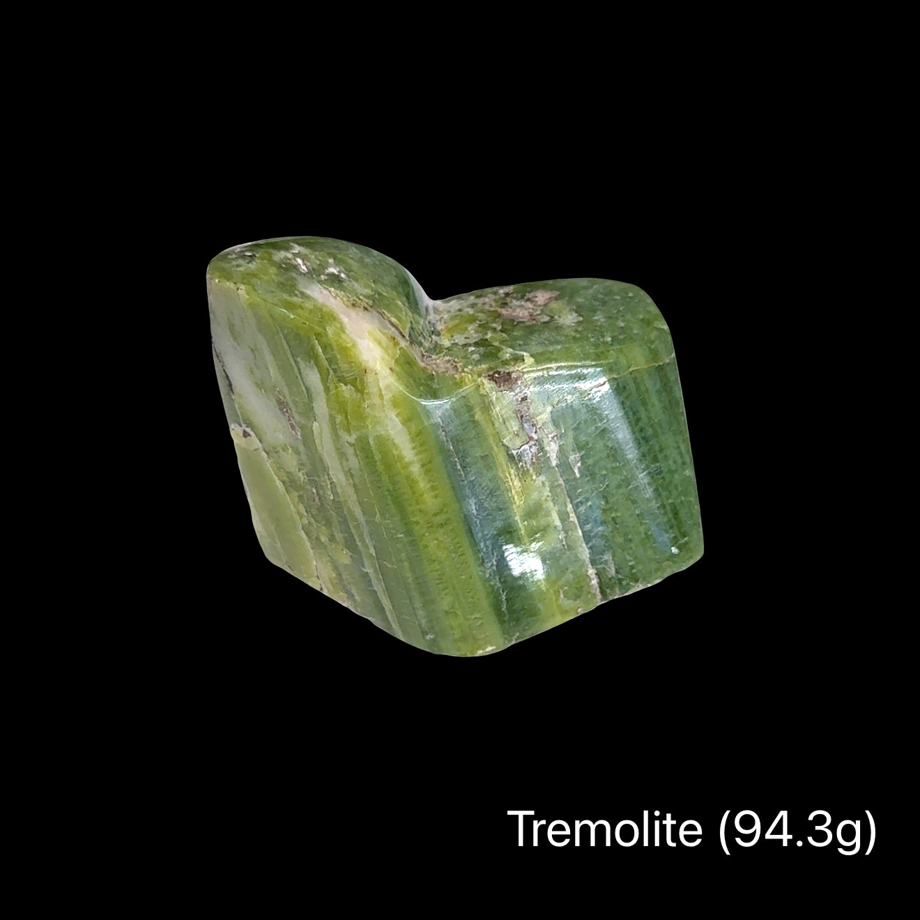 Green tremolite crystal on a black background with a weight of (94.3g), front view.