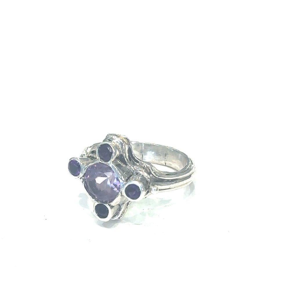 Hand‑forged sterling silver ring with 8mm faceted light Amethyst and four darker accent stones, size 7 on white slight left angle view