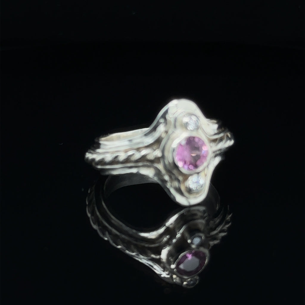 Hand‑forged sterling silver step ring with 5.4mm Pink Sapphire and two bezel‑set diamonds, size 7.5 on black front  view