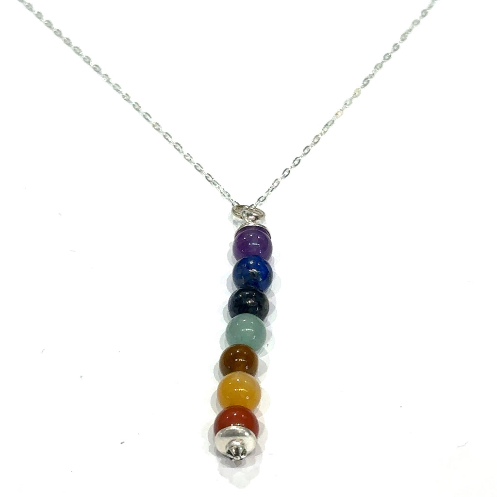 Handmade chakra gemstone beaded pendant necklace with sterling silver chain on white hanging front overview