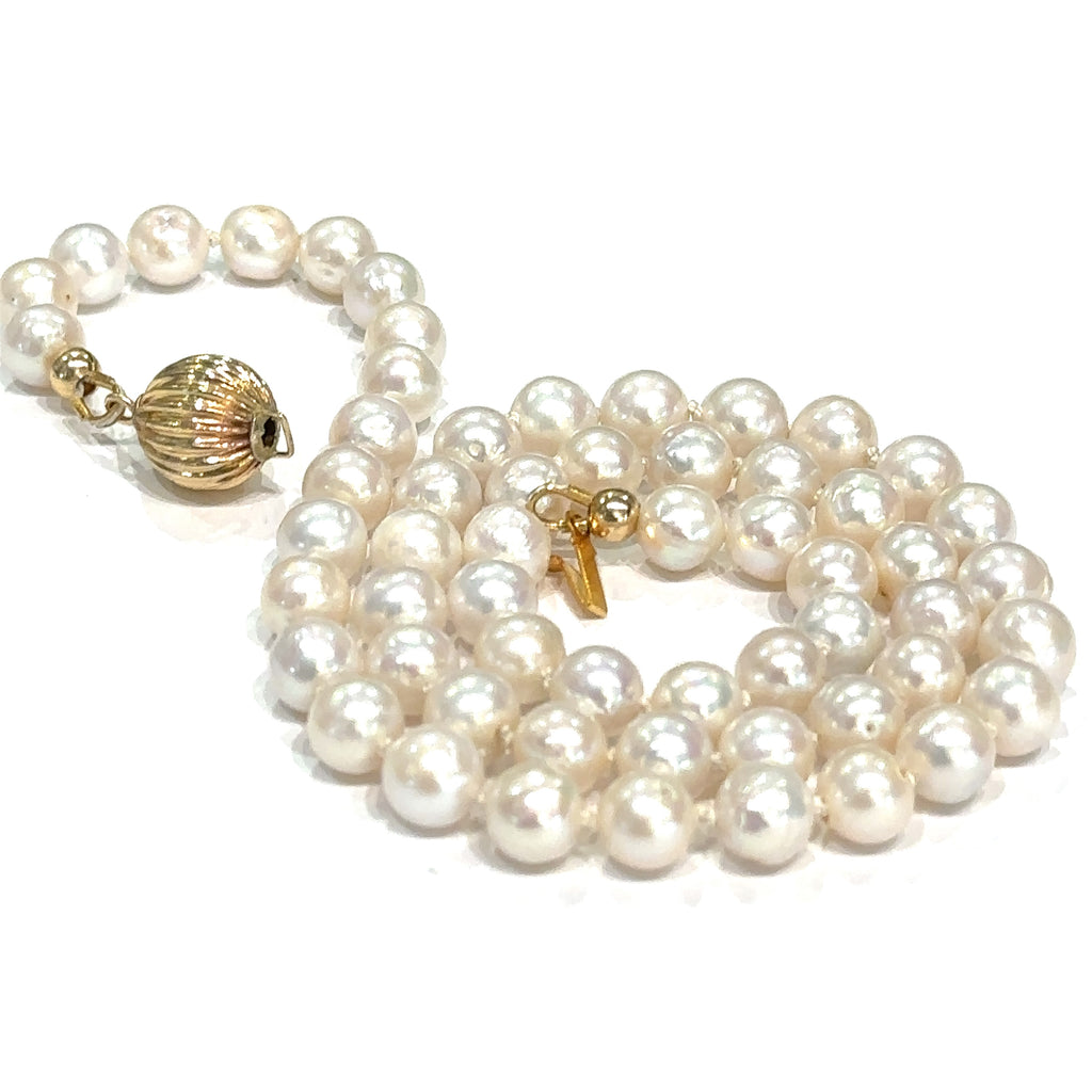 Handmade white freshwater pearl necklace with silk‑knotted strand and gold‑filled clasp on white center up close overview