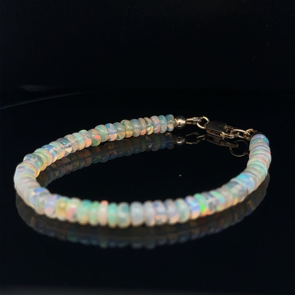 Healing Ethiopian Opal gemstone bracelet for courage, manifestation, and optimism on black left front angle view